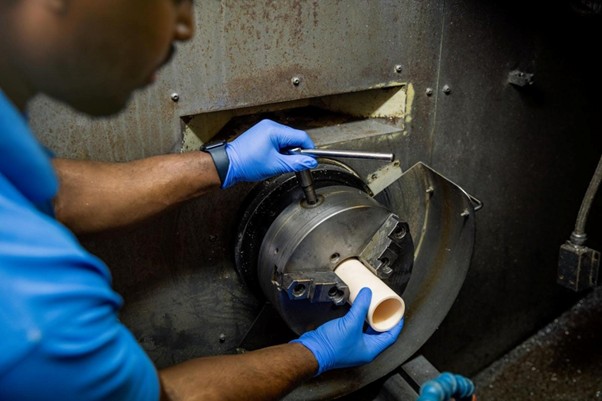 Technician demonstrating how to cut quartz tube and ceramic tubing safely using precision industrial cutting equipment.